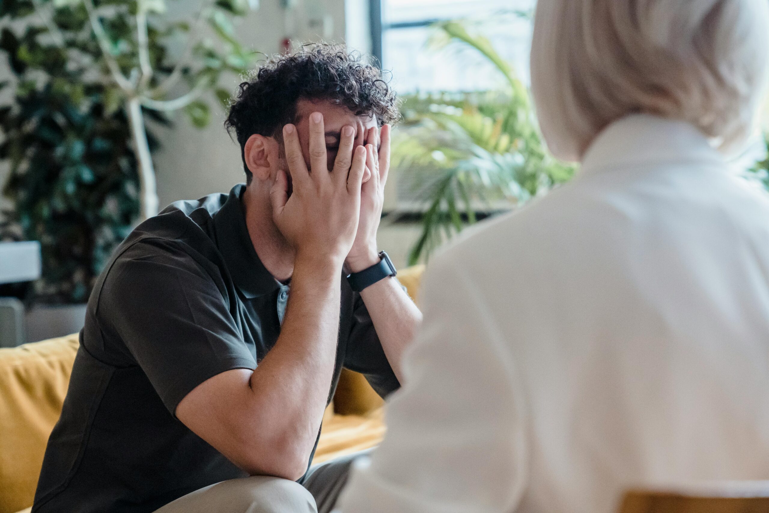 Home Man seeking support in therapy, expressing emotions during an indoor counseling session.
